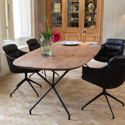 Ovale eettafel van notenhout met design eetkamerstoelen van De Sede